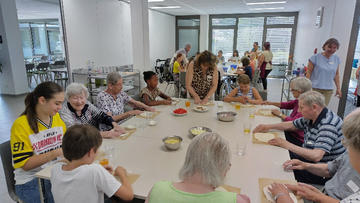 Das Bild zeigt unsere Bewohner und Kinder beim Pizza backen